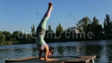 运动女孩在瑜伽时做倒立。